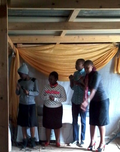 Young people presenting together on a small stage