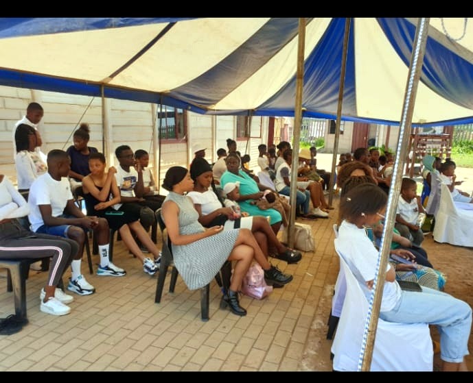 Community members seated beneath a marquee