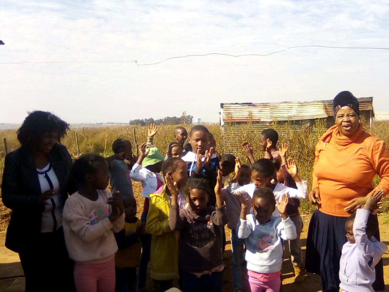Children and community volunteers gathered during an outreach visit